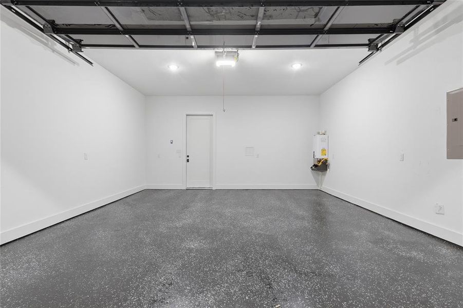 Garage featuring electric panel and water heater
