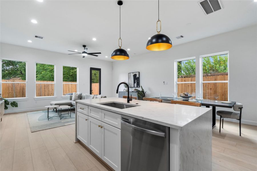 Kitchen island view showcasing open flow into the living and dining areas. Kitchen island view showcasing open flow into the living and dining areas.