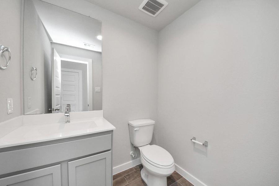 Sophisticated half bathroom adorned with contemporary finishes. The elegant 5-panel door welcomes you to a space where style meets functionality. Notice the sleek hardware accents that add a touch of modern charm. The vanity boasts light-colored countertops, creating a well-lit and inviting atmosphere. Sophisticated half bathroom adorned with contemporary finishes. The elegant 5-panel door welcomes you to a space where style meets functionality. Notice the sleek hardware accents that add a touch of modern charm. The vanity boasts light-colored countertops, creating a well-lit and inviting atmosphere.