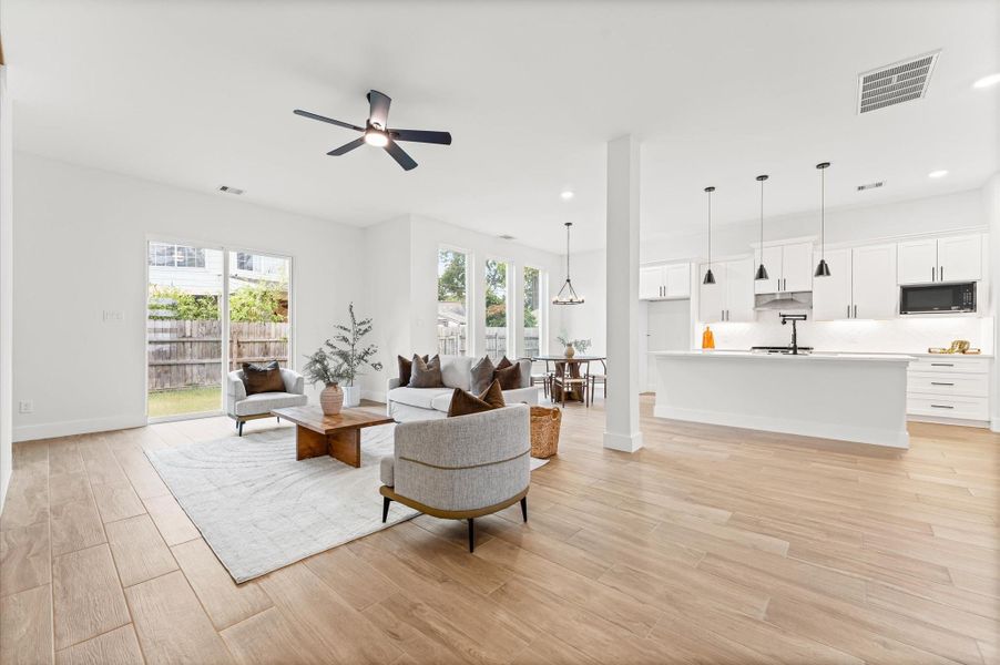 Spacious open-concept living area filled with natural light, showcasing beautiful flooring, recessed lighting, and seamless flow to the dining and kitchen areas. Spacious open-concept living area filled with natural light, showcasing beautiful flooring, recessed lighting, and seamless flow to the dining and kitchen areas.