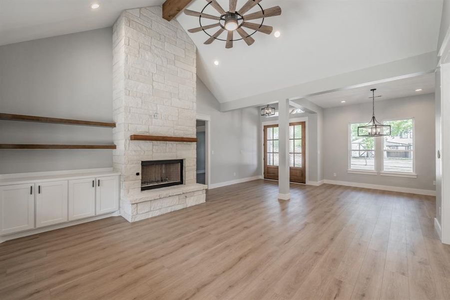 Unfurnished living room with light hardwood / wood-style flooring, a fireplace, ceiling fan, and a healthy amount of sunlight