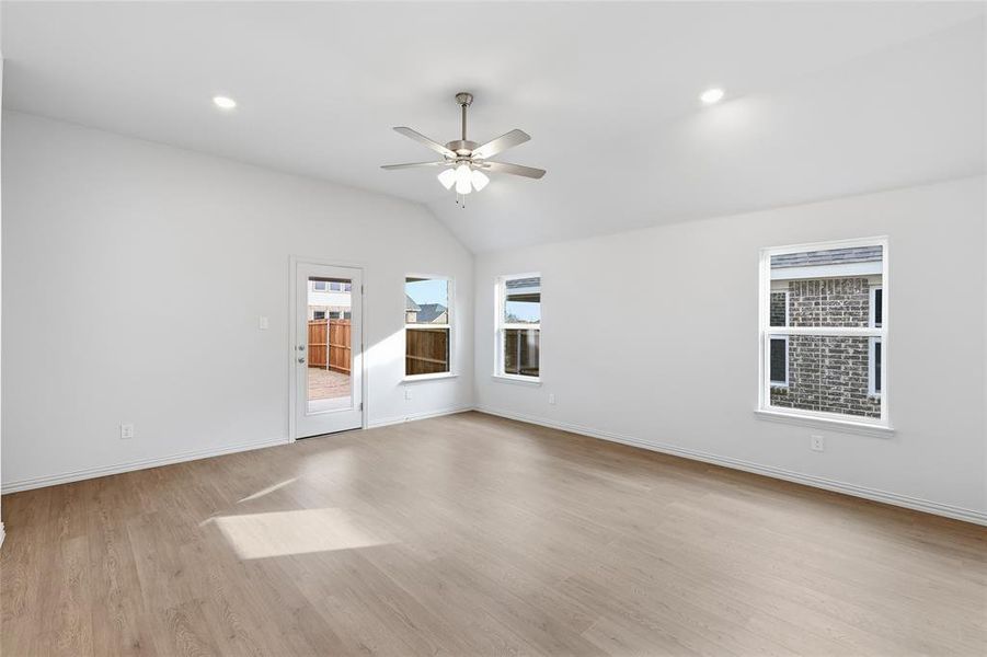 Spare room featuring ceiling fan, vaulted ceiling, light wood finished floors, and recessed lighting