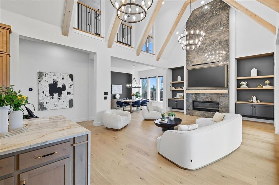 Living room featuring built in shelves & cabinets, a high end fireplace, and light hardwood flooring Living room featuring built in shelves & cabinets, a high end fireplace, and light hardwood flooring