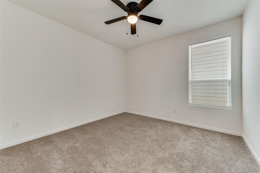 Spare room featuring light colored carpet and ceiling fan