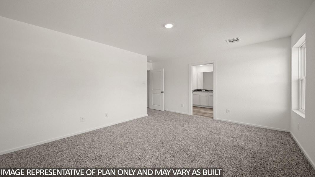 Spacious carpeted room featuring a single window for natural light, a recessed ceiling light, and an open doorway leading to a bathroom with a double vanity and light wood-finish flooring