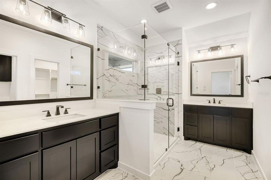 Bathroom featuring a marble finish shower, two vanities, a spacious closet, and recessed lighting