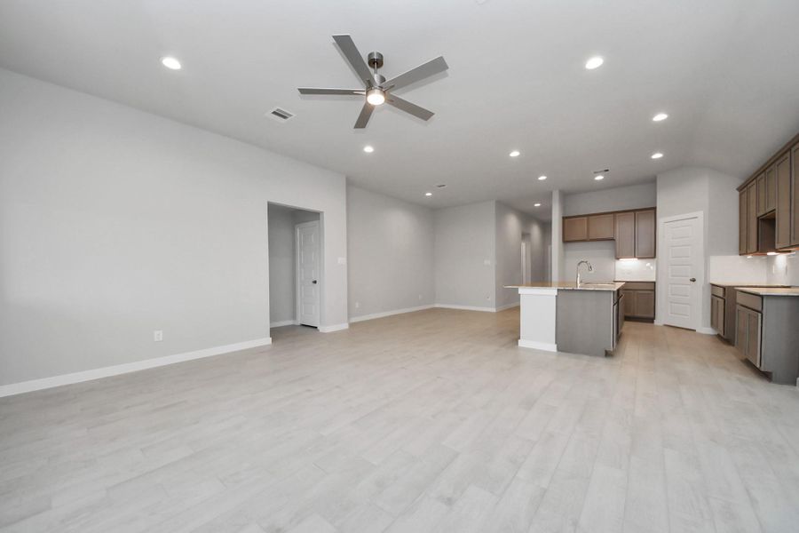 Gather the family and guests together in your lovely living room! Featuring soaring high ceilings, recessed lighting, ceiling fan, custom paint, gorgeous floors, and large windows that provide plenty of natural lighting throughout the day. Sample photo of completed home with similar floor plan. Actual colors and selections may vary.
