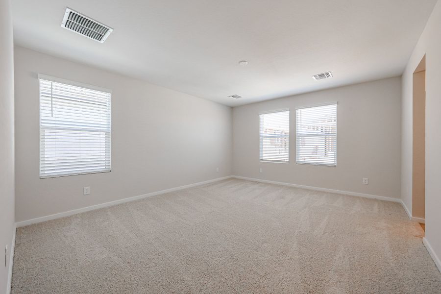 A room with a carpet and windows.