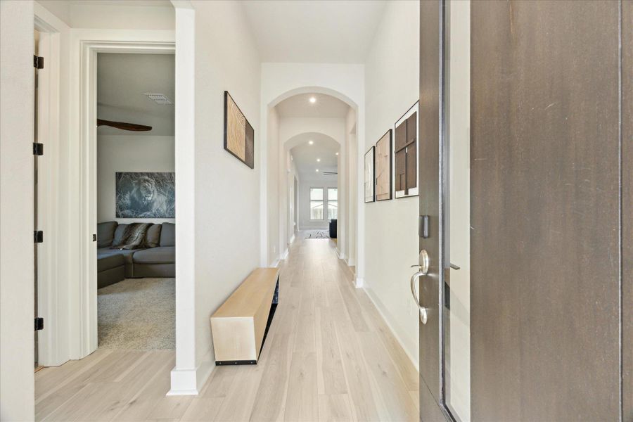 Entry featuring tall arched hallways, and light wood-style flooring