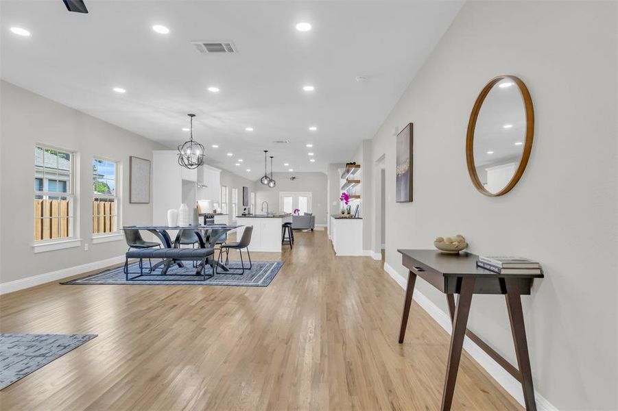 Living area with recessed lighting, light wood-style floors, and a chandelier