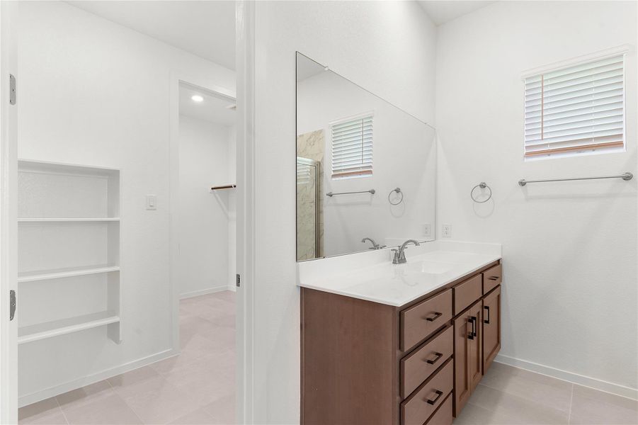 Bathroom featuring vanity, a shower stall, baseboards, and tile patterned floors