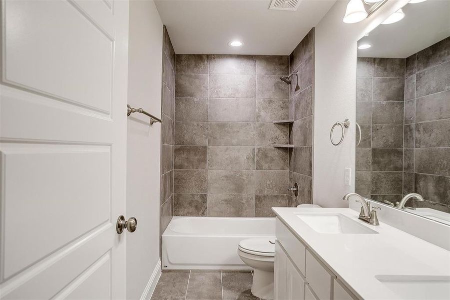 Full bath with toilet, recessed lighting, a sink,  shower combination, and double vanity