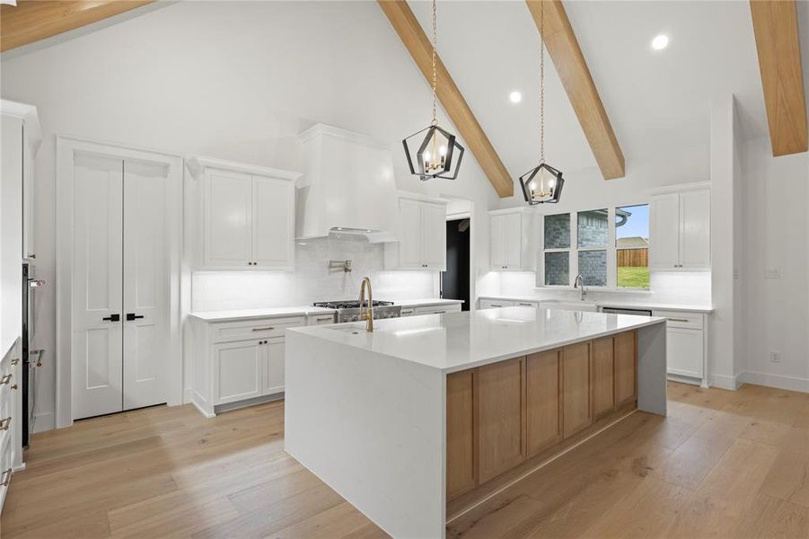 Vaulted ceiling kitchen featuring exposed wood beams and recessed lighting