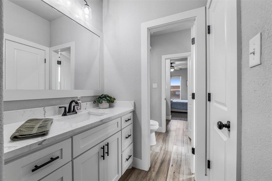 Bathroom featuring vanity, wood-type flooring, and toilet