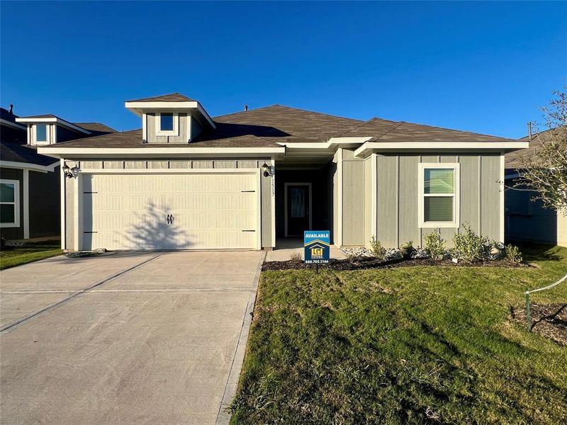 View of front facade featuring a garage and a front yard