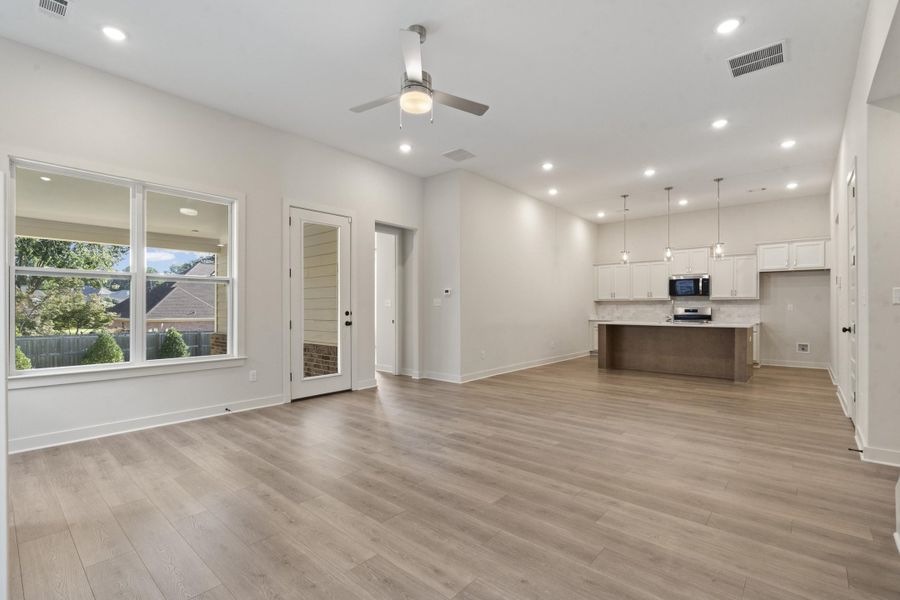 Open-concept living space featuring wood-finish flooring, recessed lighting, and a ceiling fan Open-concept living space featuring wood-finish flooring, recessed lighting, and a ceiling fan