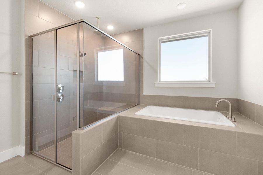 Full bathroom featuring a shower stall, a garden tub, light tile patterned flooring, plenty of natural light, and recessed lighting