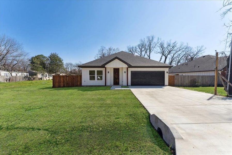 Single story home featuring a front lawn and a garage