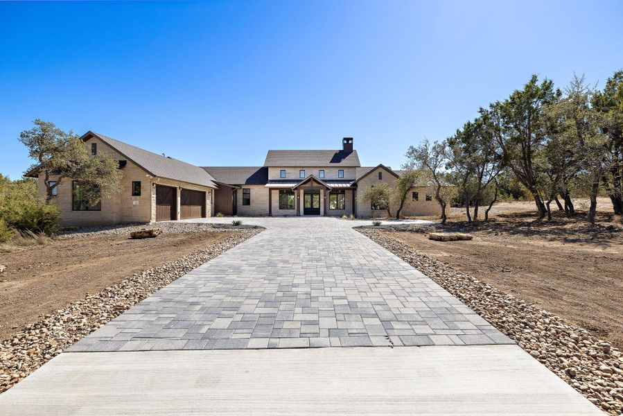 View of front facade with an attached garage and decorative driveway