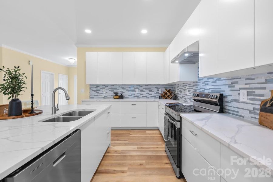 flat-panel cabinetry, quartz countertops, tile backsplash & brand new stainless appliances