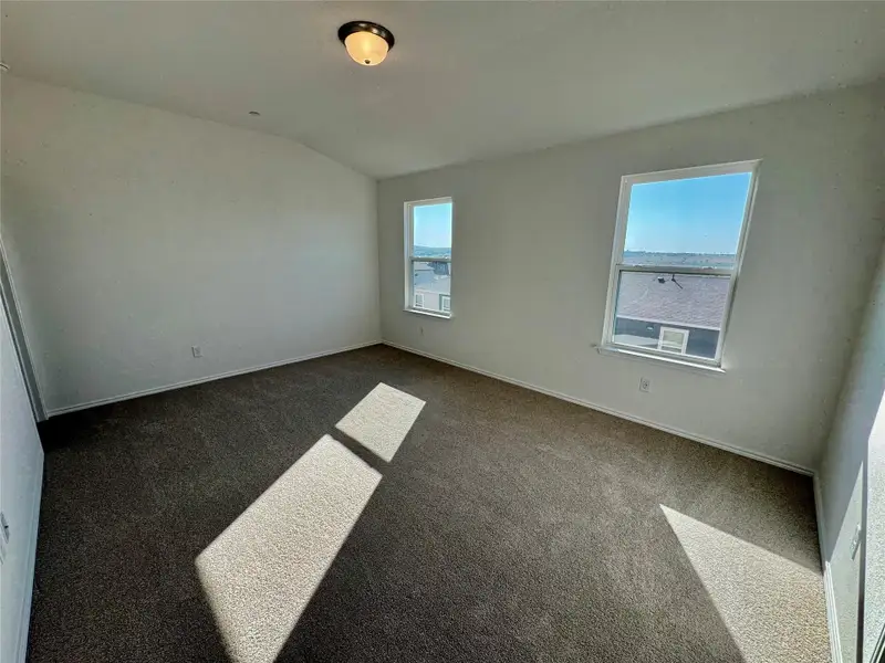 Empty room featuring carpet, lofted ceiling, and healthy amount of natural light Empty room featuring carpet, lofted ceiling, and healthy amount of natural light