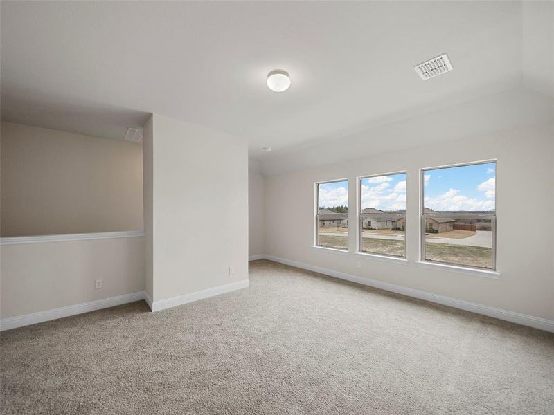 Empty room with carpet, visible vents, and baseboards