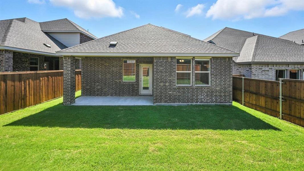 Back of house with a patio, a fenced backyard, brick siding, and roof with shingles