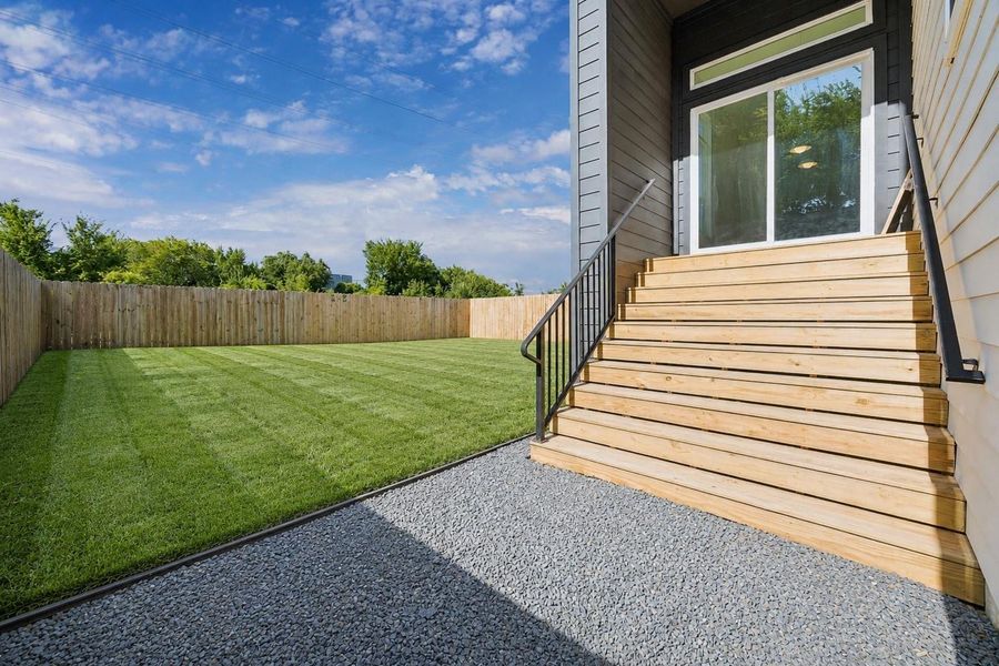 An elevated deck overlooks one of the area’s larger fenced backyards, providing exceptional space for entertaining, play, gardening, or a future pool.