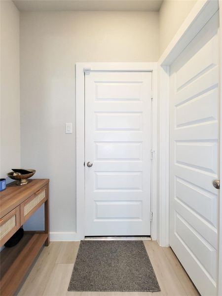 This entryway features a clean, modern design with light-color walls and flooring, providing a fresh, welcoming atmosphere.