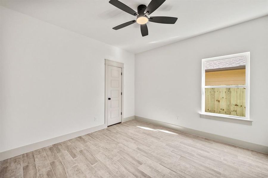 Empty room featuring light wood-type flooring and ceiling fan