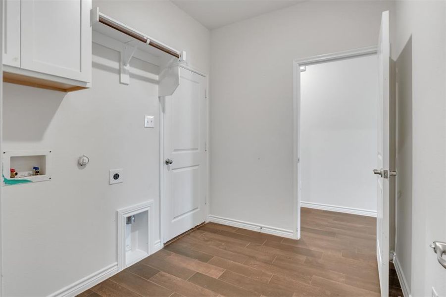 Laundry area featuring hookup for a gas dryer, cabinets, electric dryer hookup, hardwood / wood-style flooring, and washer hookup