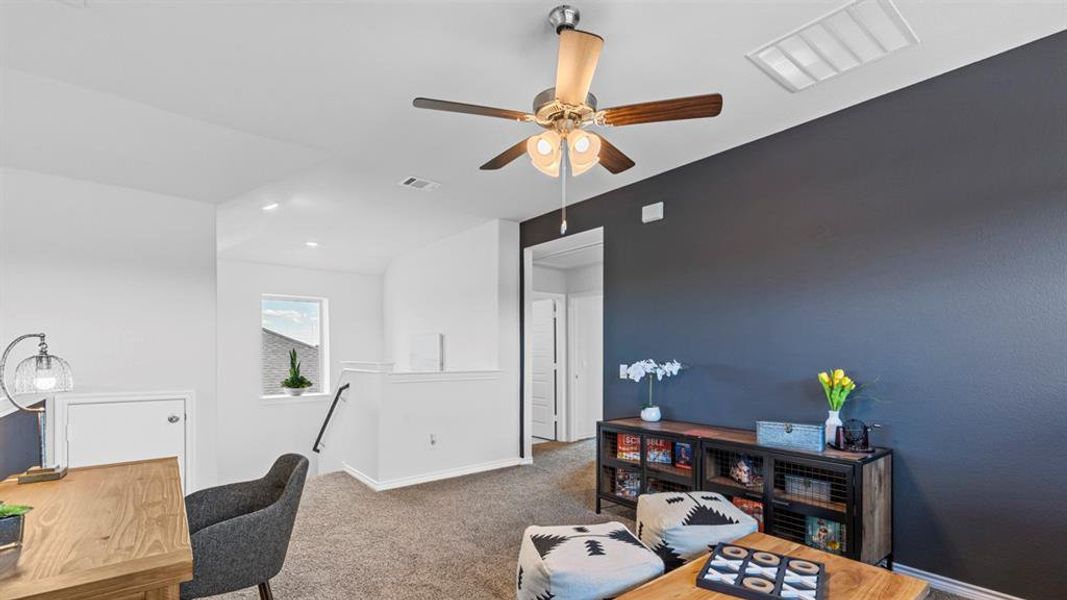 Upper-level flexible space featuring a ceiling fan with integrated lighting, a contrasting accent wall, and plush carpeting Upper-level flexible space featuring a ceiling fan with integrated lighting, a contrasting accent wall, and plush carpeting