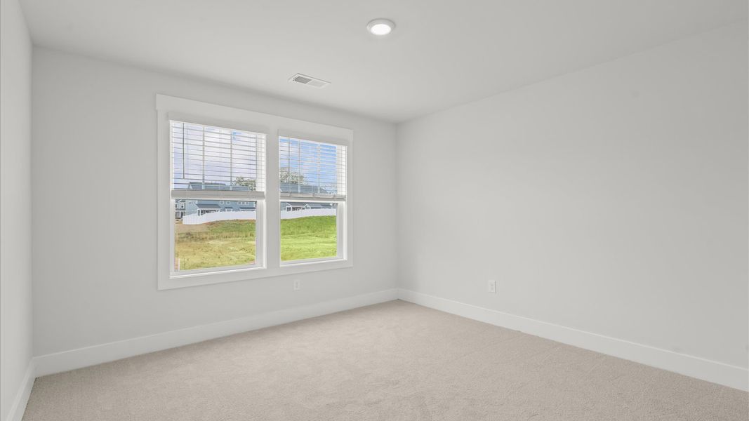 Elegant bedroom retreat featuring soft carpet and oversized windows that create a bright, welcoming space Elegant bedroom retreat featuring soft carpet and oversized windows that create a bright, welcoming space