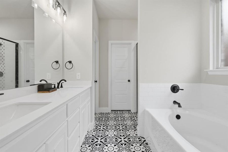 Bathroom with double vanity, a garden tub, a shower stall, and light tile patterned flooring