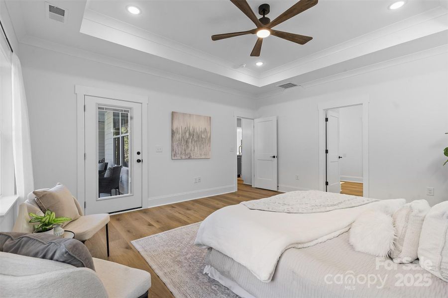 *representative photo- primary bedroom w/ tray ceiling, additional windows for natural light, ensuite bathroom, and a private access to the covered back porch!