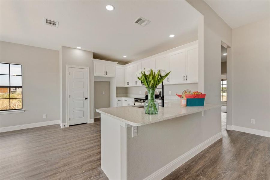 Kitchen featuring dark hardwood / wood-style flooring, kitchen peninsula, and a wealth of natural light