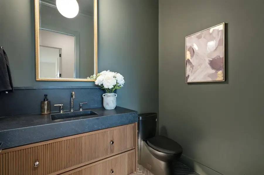 Half bath featuring vanity and toilet Half bath featuring vanity and toilet