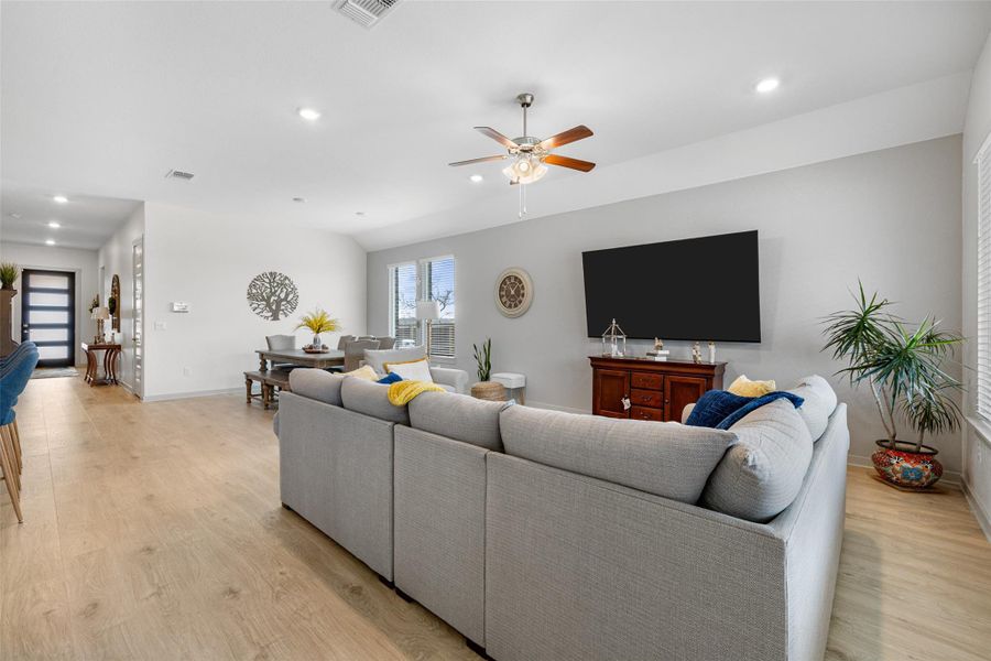 Living area featuring light wood-type flooring, recessed lighting, and a ceiling fan Living area featuring light wood-type flooring, recessed lighting, and a ceiling fan