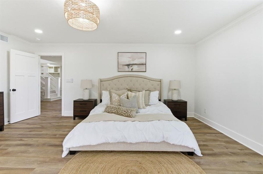 This room features light wood-style flooring, white walls, and a decorative ceiling light fixture This room features light wood-style flooring, white walls, and a decorative ceiling light fixture