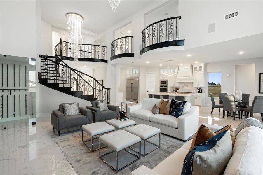 Living room with marble finish floor, recessed lighting, visible vents, an inviting chandelier, and stairs