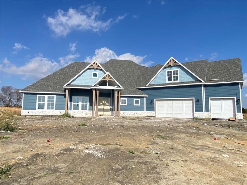 View of front of home featuring roof with shingles, a garage, covered porch, and stone siding View of front of home featuring roof with shingles, a garage, covered porch, and stone siding