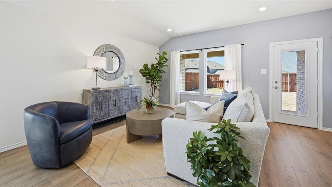 Living space with light-colored walls, recessed lighting, and wood-look flooring