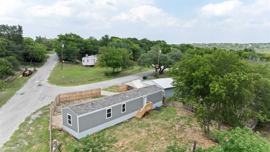 Gray manufactured home with white trim windows and a natural wood staircase