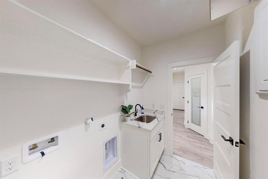 Laundry area with sink, cabinets, hookup for an electric dryer, hookup for a washing machine, and light hardwood / wood-style floors