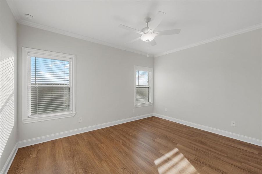 Spare room featuring ornamental molding, wood finished floors, and a ceiling fan Spare room featuring ornamental molding, wood finished floors, and a ceiling fan