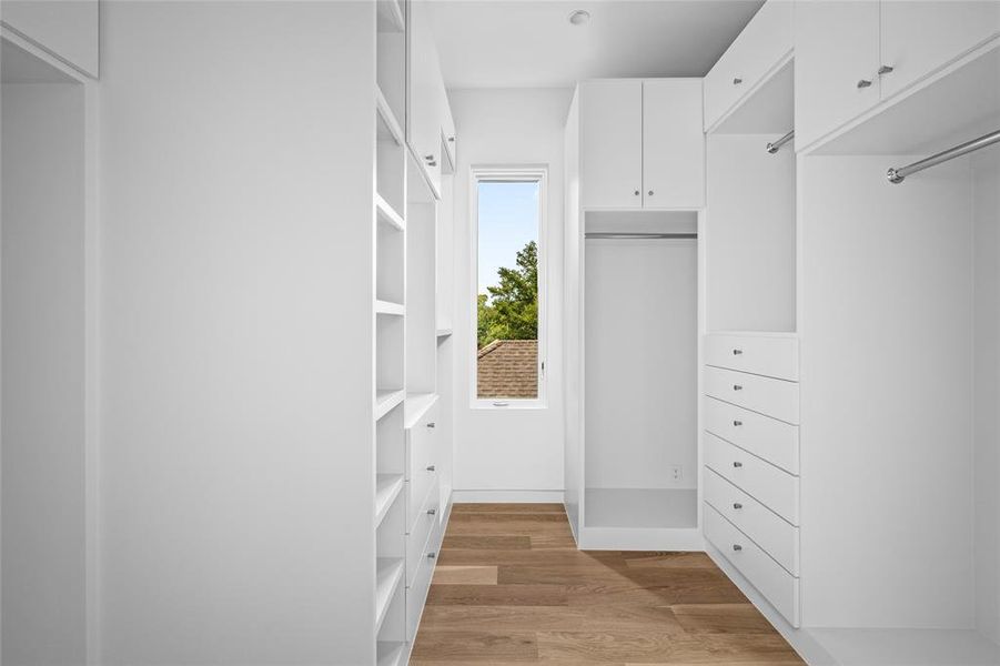 One of two primary closets, this incredible space is designed with built-in storage solutions and ample hanging racks, all featuring polished nickel hardware for a sleek and modern finish.