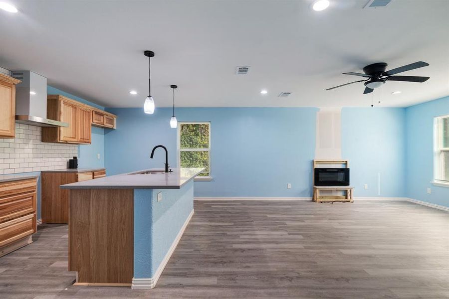 Kitchen with decorative backsplash, wall chimney range hood, recessed lighting, dark wood-style floors, and open floor plan Kitchen with decorative backsplash, wall chimney range hood, recessed lighting, dark wood-style floors, and open floor plan