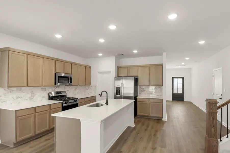 Kitchen featuring decorative backsplash, appliances with stainless steel finishes, recessed lighting, dark wood-type flooring, and a kitchen island with sink Kitchen featuring decorative backsplash, appliances with stainless steel finishes, recessed lighting, dark wood-type flooring, and a kitchen island with sink