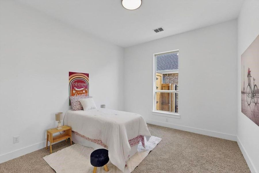 Bedroom featuring carpet and baseboards