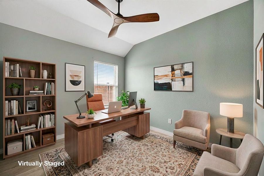 Office area featuring a ceiling fan, vaulted ceiling, and light wood-style floors